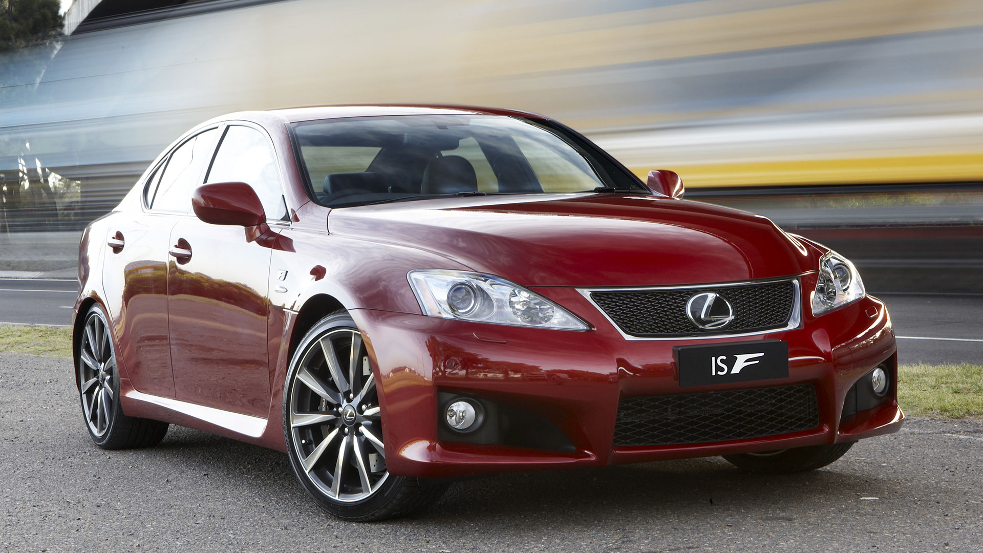 A front three-quarter view of a red Lexus IS F sports sedan parked outdoors.